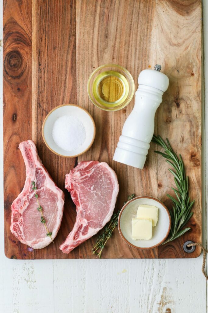 Ingredients for pan seared pork chops on a cutting board
