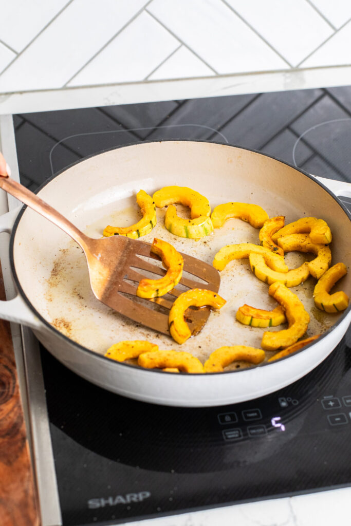 Delicata squash being flipped over to sear on the other side while cooking on a Sharp Induction Cooktop