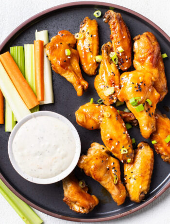chicken wings on a plate with veggies