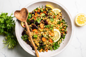  a beet quinoa salad with roasted carrots topped with pistachios and pine nuts.