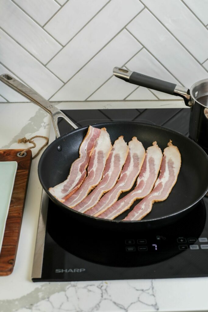 Bacon cooking in a pan on a Sharp Induction Cooktop SCH3042GB