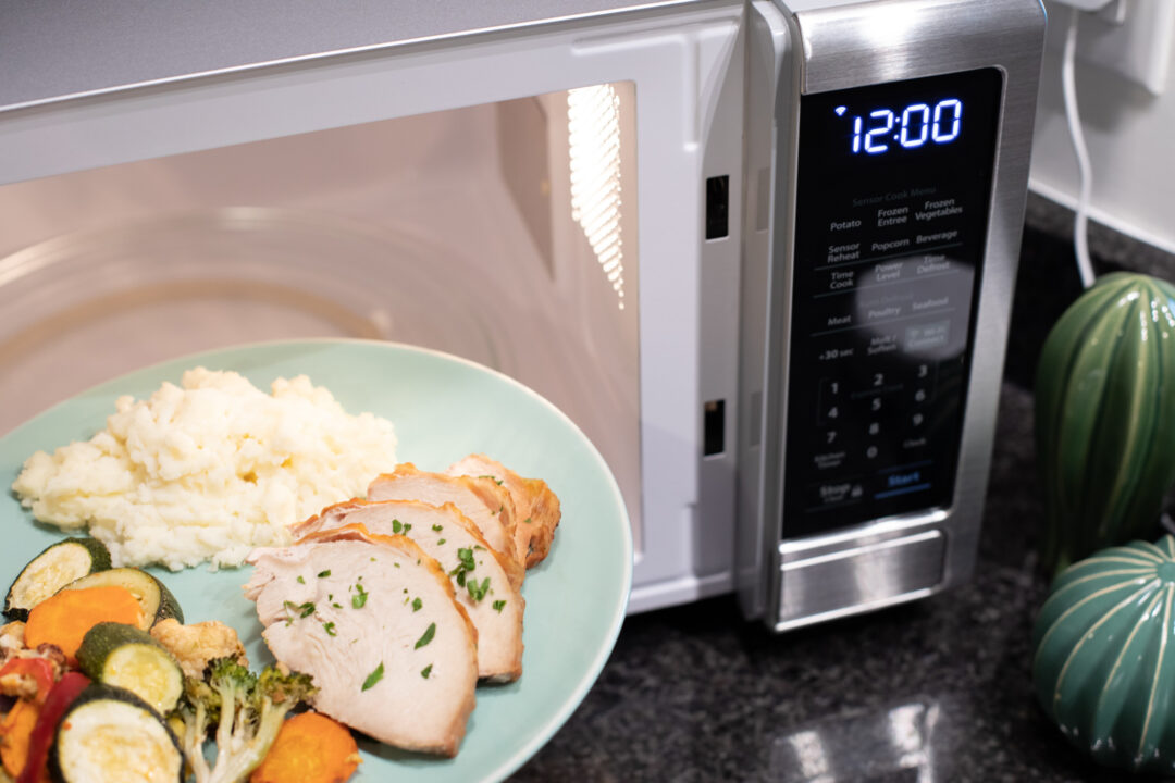 meal on a plate being put into a Sharp microwave