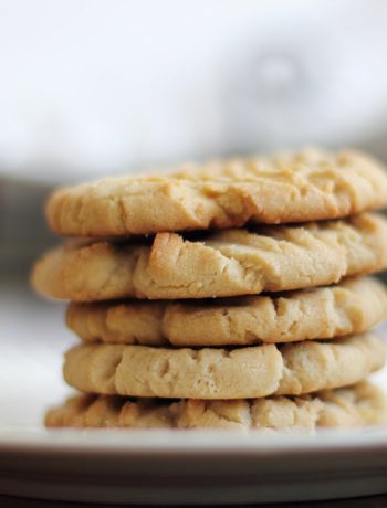 Pumpkin cookies stacked upon one another on a plate.