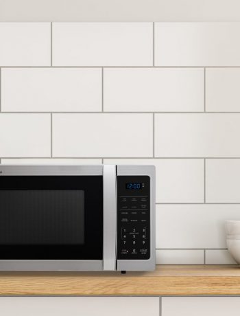 Sharp microwave on a countertop next to a bowl and a jar.