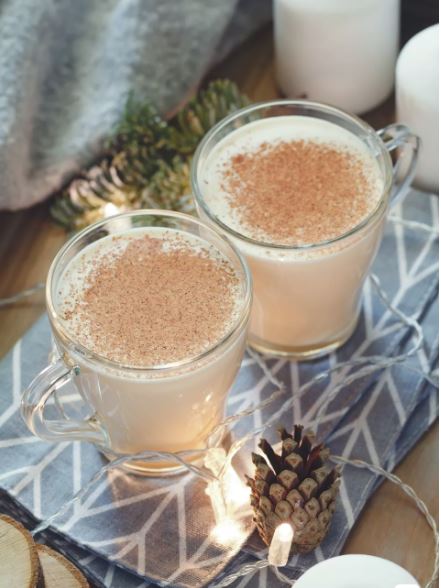 Two cups of eggnog with holiday decor.