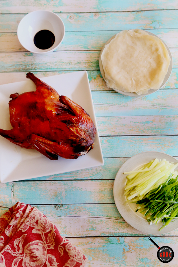Peking Duck and ingredients on a table.