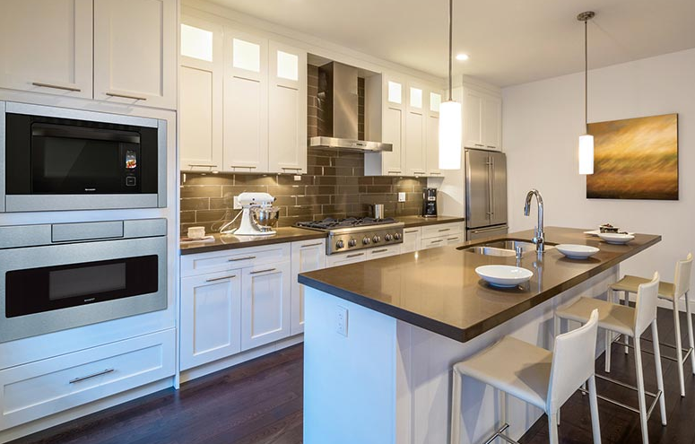 Modern kitchen design with Sharp appliances and grey subway tile back splash.