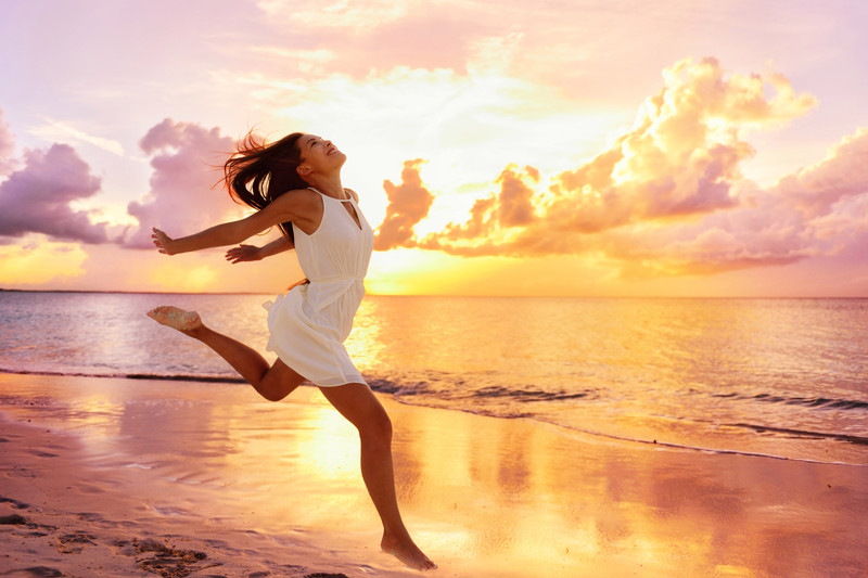 Woman running with joy across the ocean.