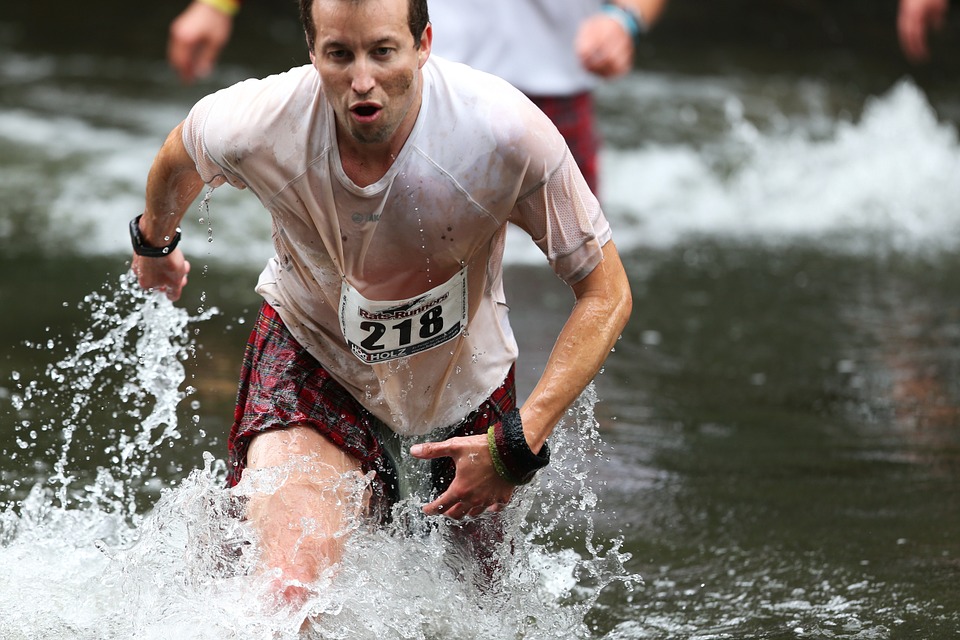 A man coming out of a lake during a marathon.