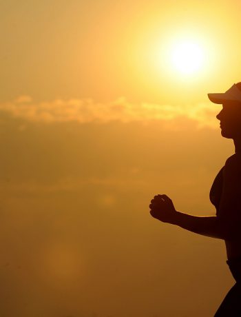 Woman jogging along a sunset.