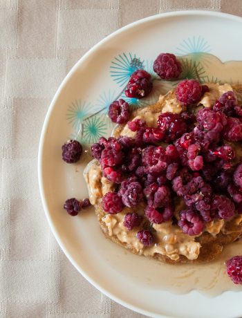 Peanut butter and rasberries on a dish.