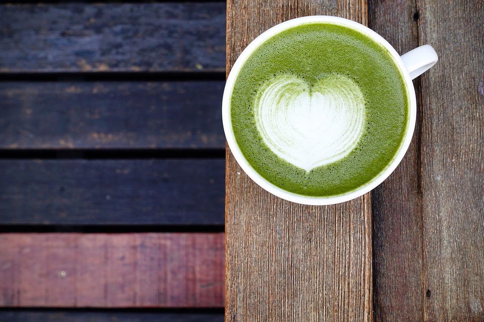 Matcha latte on a wooden outdoor surface.