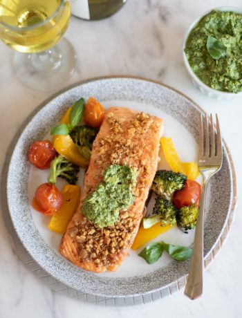 Baked Pesto Salmon on a plate next to a fork.