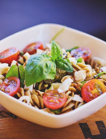 Pasta salad in a white bowl.