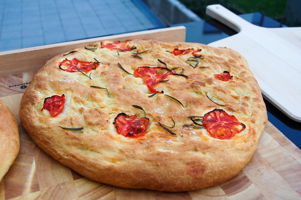Foccaccia on a wooden surface outside.