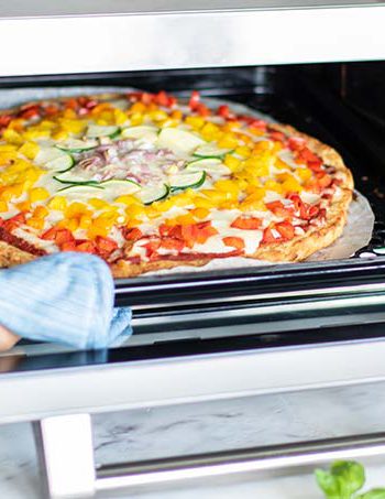 Pizza entering a Sharp Supersteam Oven.