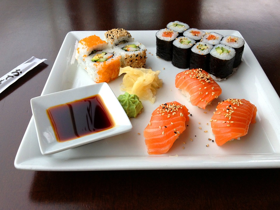 Sushi on a white square plate with sauce.