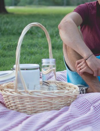 Picnic setting with a basket outdoors.