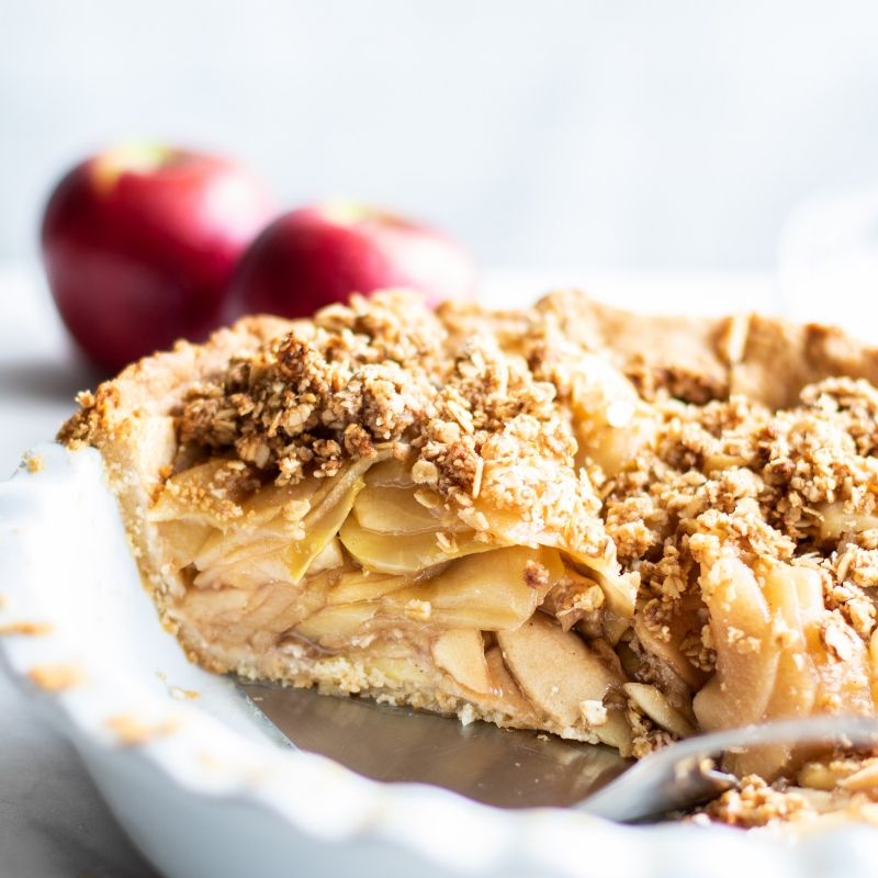 Apple crumb pie in a white dish.