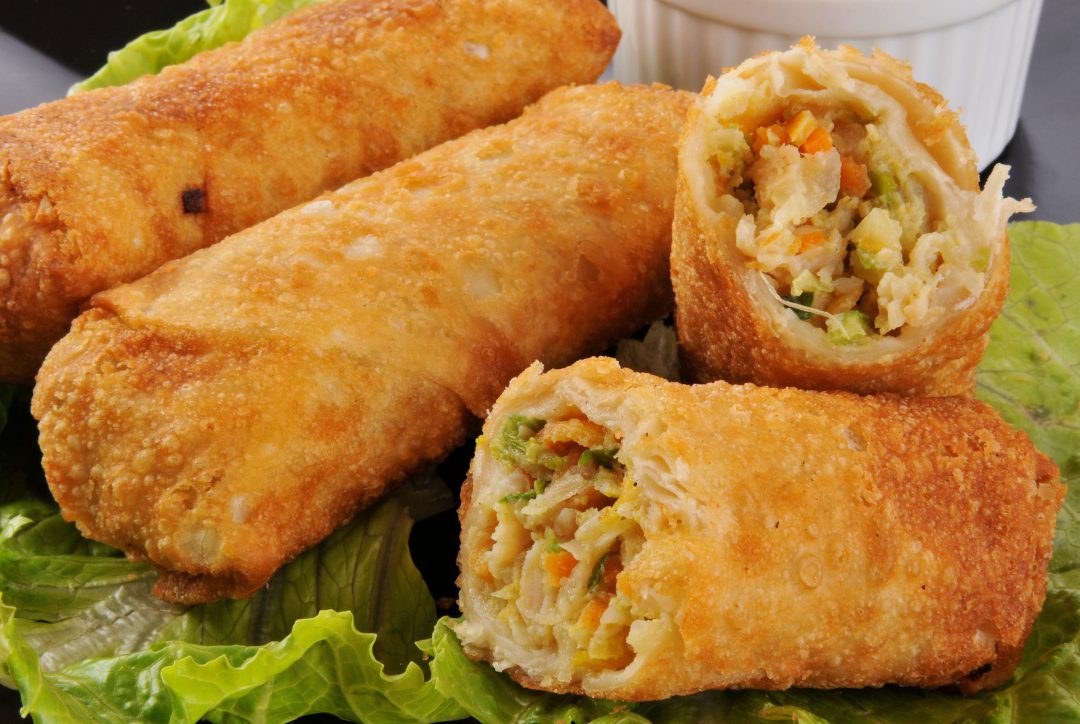 Egg rolls stacked upon one another on celery.