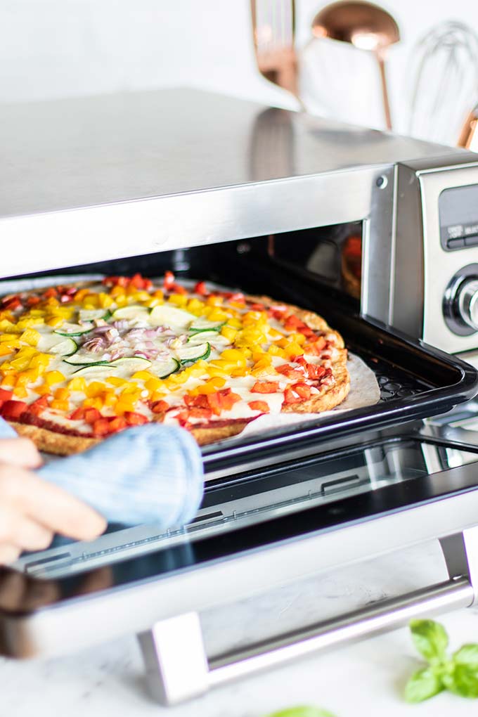 Pizza coming out of a Sharp Supersteam Countertop Oven.