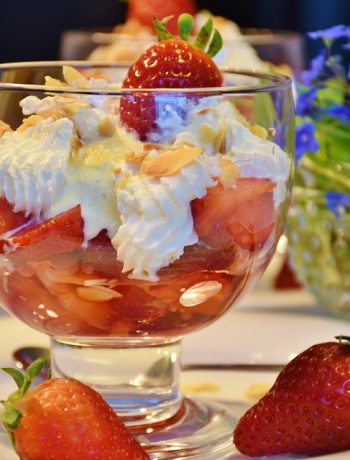 Strawberry Sundae Sauce in a bowl next to strawberrys.