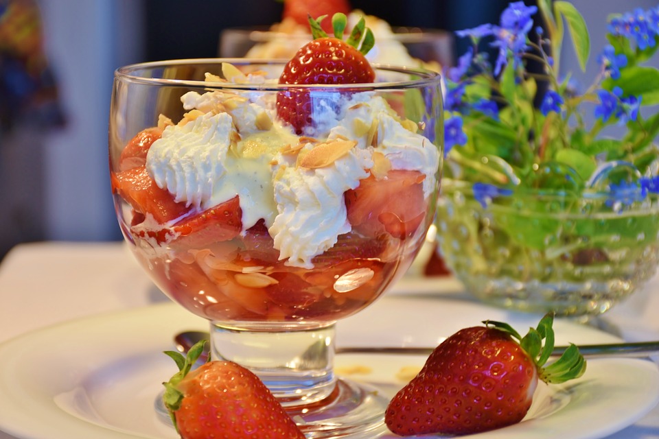 Strawberry Sundae Sauce in a bowl next to strawberrys.