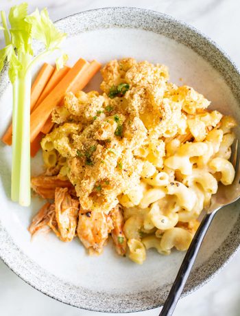 Buffallo mac and cheese with carrots on a plate with a fork.