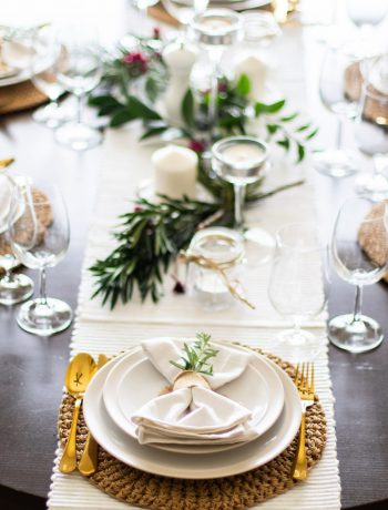 Table setting with glass and gold silverware.
