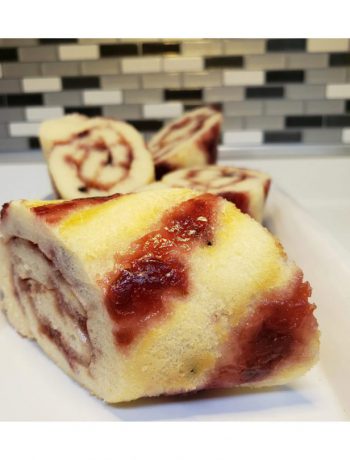 Cherry jam pancake rolls on a tray on a countertop.