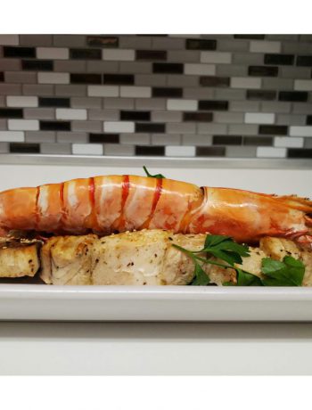 Swordfish and jumbo prawn kebabs on a countertop.