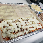 Cheese sauce on top of tin foil wrapped tray.