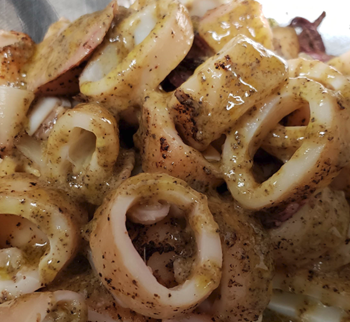 Calamari in a bowl with liquid topping.