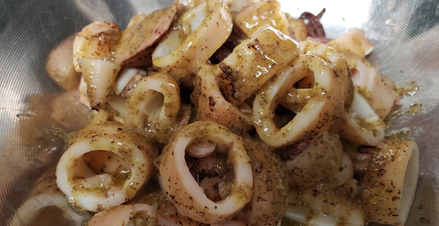 Calamari in a bowl with liquid topping.