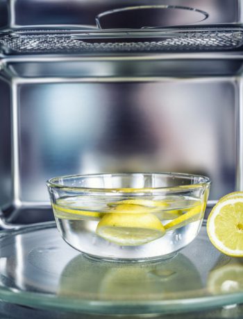 Bowl of water with lemons inside a microwave.