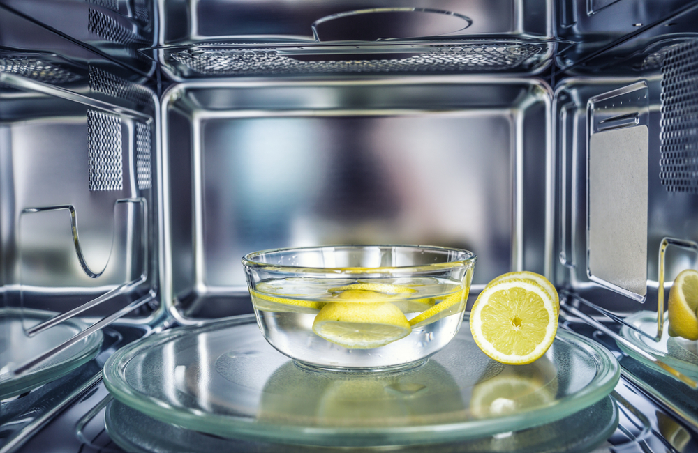 Bowl of water with lemons inside a microwave.