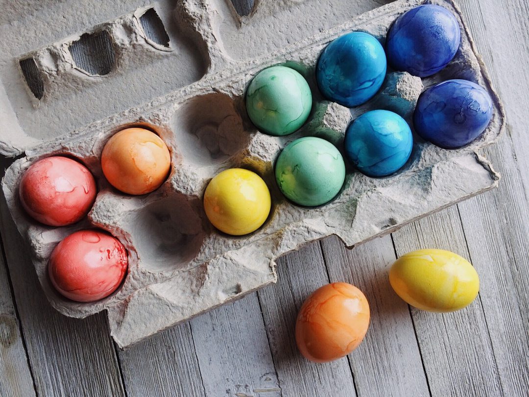 Dyed colored eggs in a carton.
