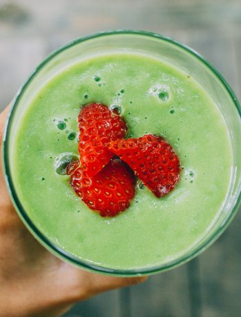 Avocado smoothie with strawberries on top.