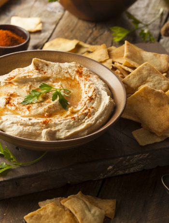 board with pita chips and a bowl of hummus