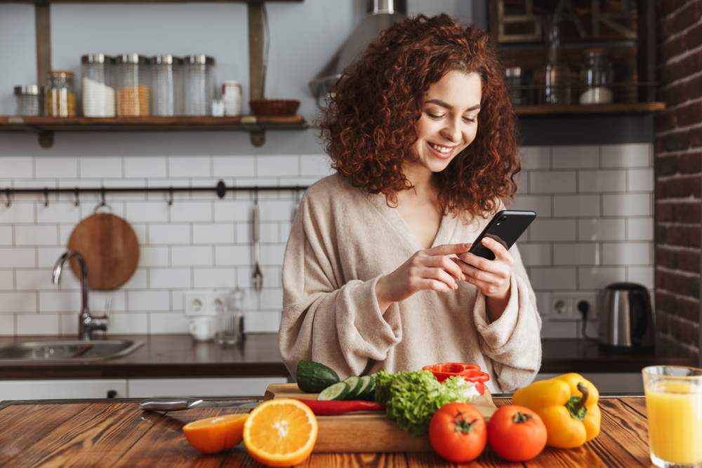 woman on her smartphone in the kitchen