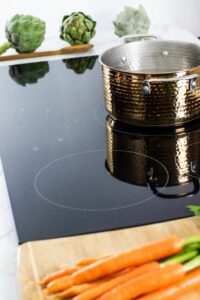 induction cooktop with pot and veggies