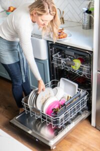 Woman loading dishwasher