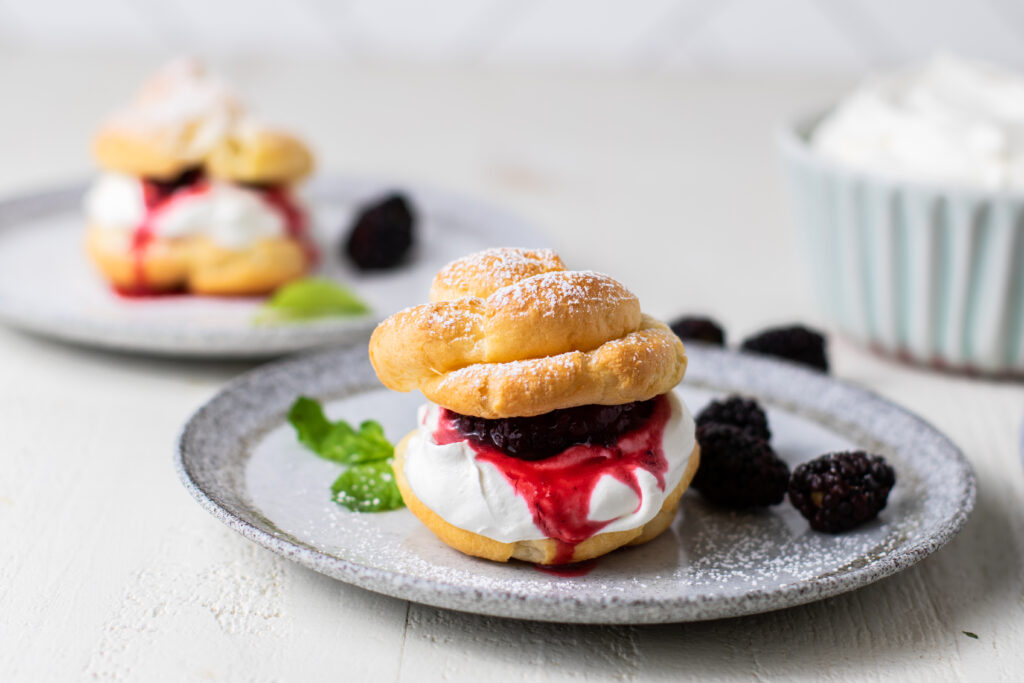 Cream Puff pastry on a dish with a blackberry sauce
