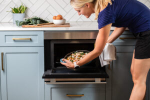 Woman placing skillet in Sharp Steam oven