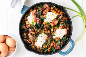Sweet potato breakfast skillet on a white background with eggs