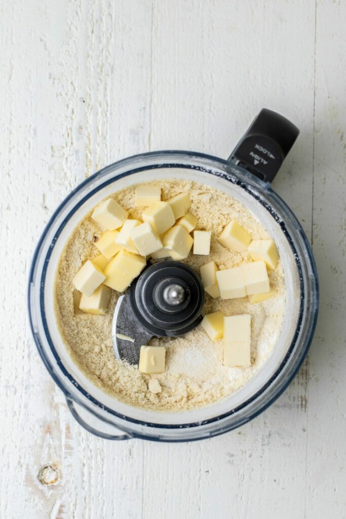 chopped up butter in a food processor with dry ingredients