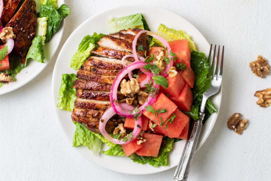 Watermelon balsamic chicken salad on a plate with a fork