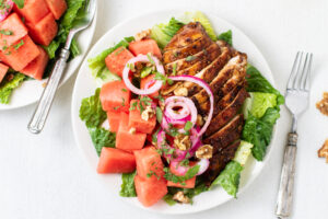 watermelon balsamic chicken salad on white plate and table