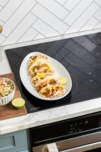 Shrimp Tacos plated sitting on a Sharp Induction cooktop