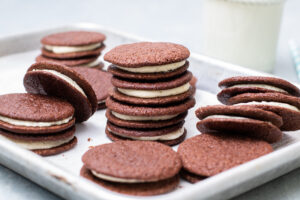 Chocolate Sandwich Cookies stacked on a baking tray